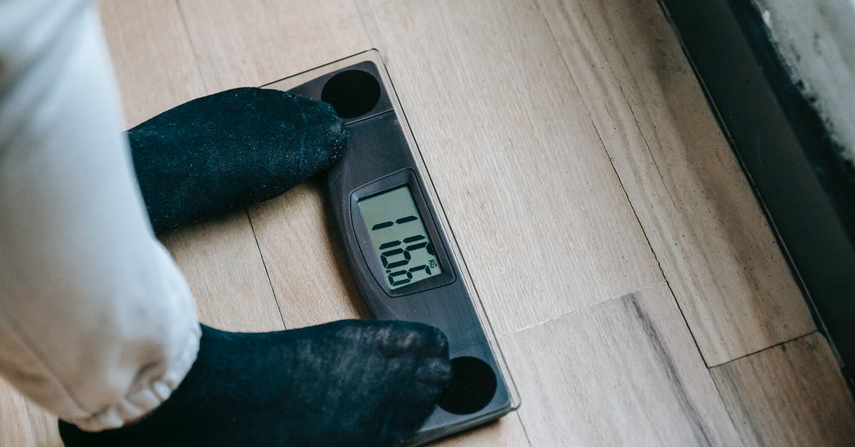Cups v. weighing scales - is there an historical explanation? - From above of unrecognizable person in socks standing on electronic weighing scales while checking weight on parquet during weight loss Cups v. weighing scales - is there an historical explanation? - From above of unrecognizable person in socks standing on electronic weighing scales while checking weight on parquet during weight loss