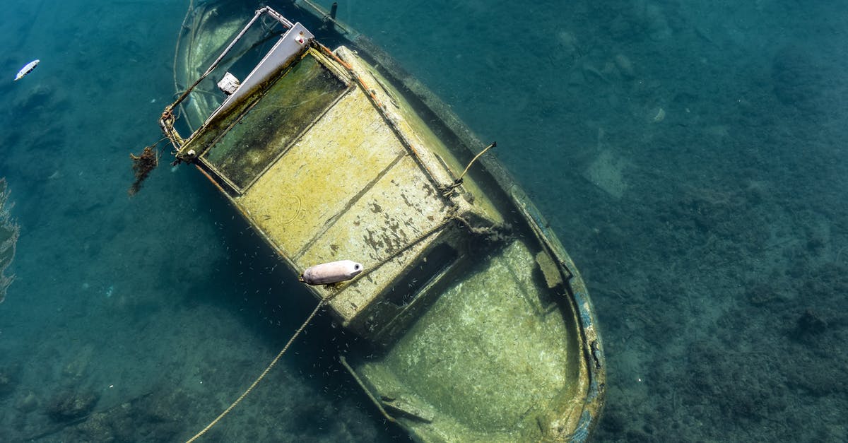 Damage to pan bottom - Small wrecked shabby boat undersea in daytime Damage to pan bottom - Small wrecked shabby boat undersea in daytime