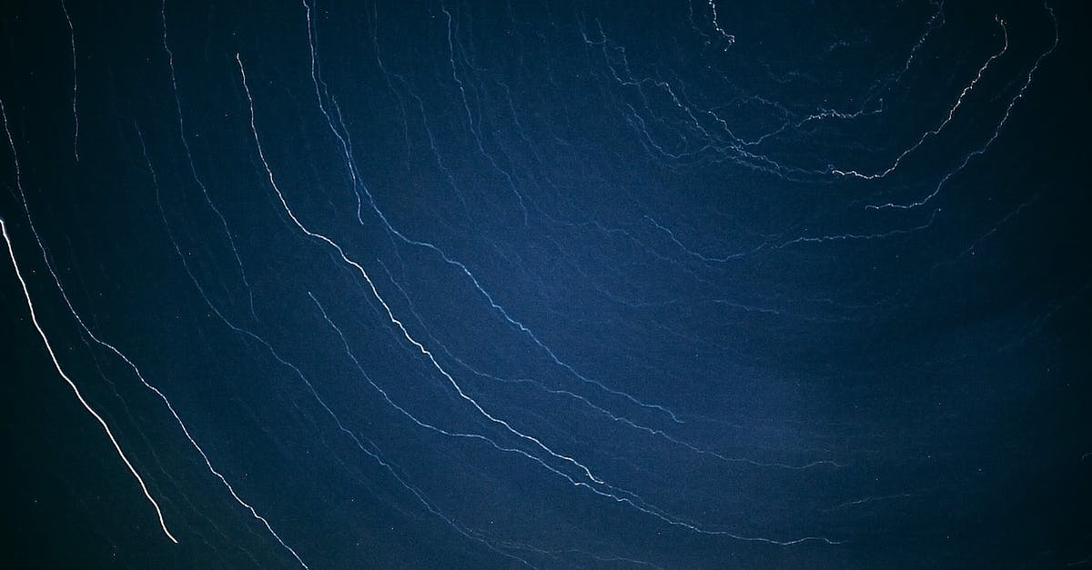 Date cookies are thin and spread out - Abstract backdrop of white wavy thin lines in row on dark blue surface Date cookies are thin and spread out - Abstract backdrop of white wavy thin lines in row on dark blue surface