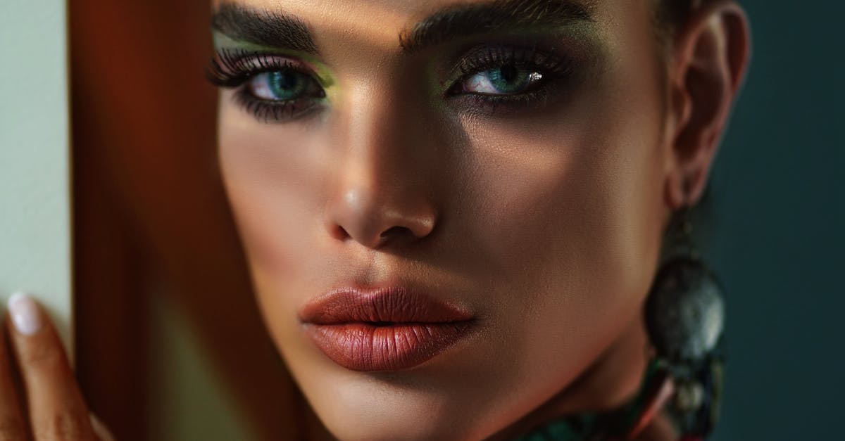 Deep frying and burning eyes - Crop stylish model with makeup near wall Deep frying and burning eyes - Crop stylish model with makeup near wall