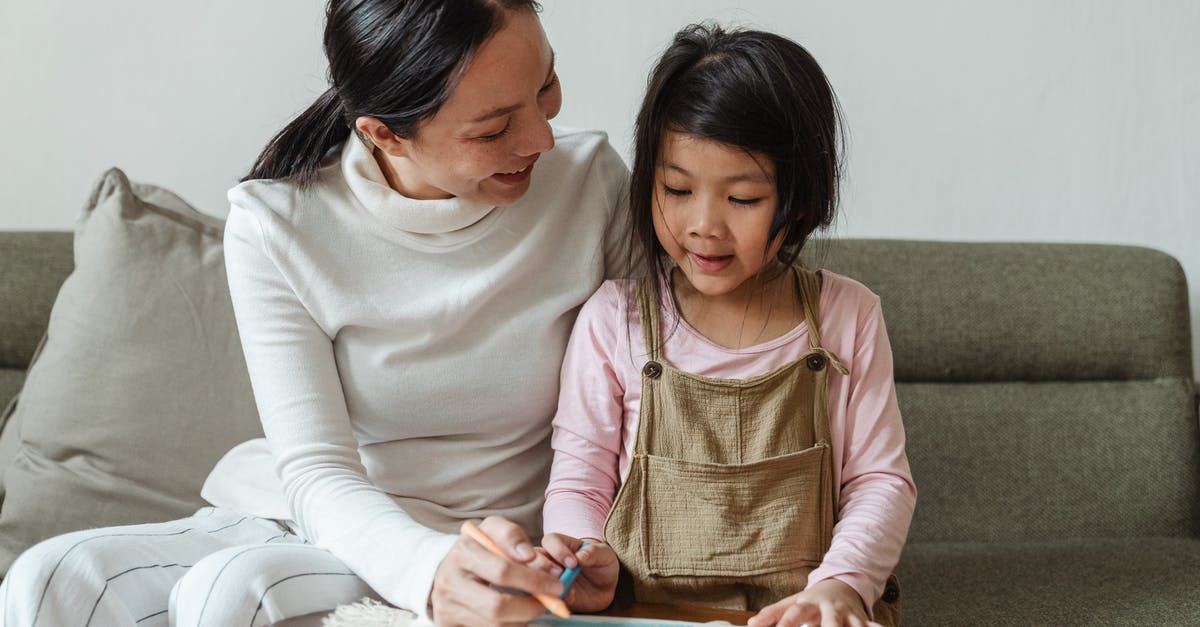 Dehydrating Strawberries - Wax Paper or Parchment? - Smiling woman tutoring ethnic girl at home Dehydrating Strawberries - Wax Paper or Parchment? - Smiling woman tutoring ethnic girl at home