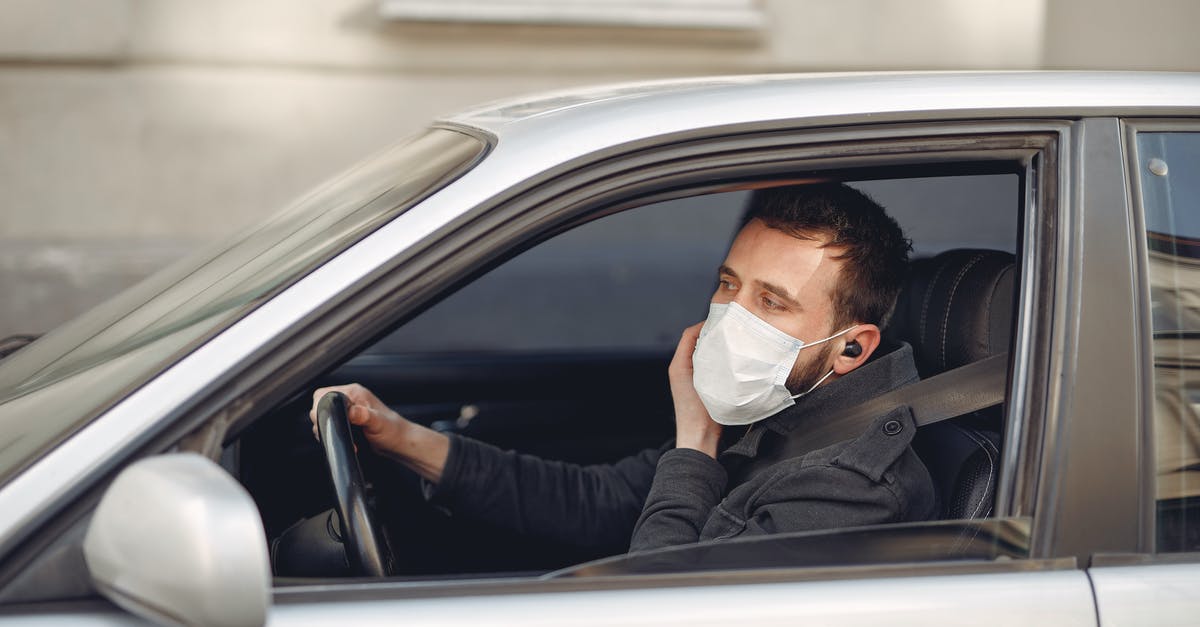 deli ham left in warm car - Serious bearded male driver wearing warm jacket and protective facial mask using wireless earphones sitting in auto with opened window during coronavirus pandemic deli ham left in warm car - Serious bearded male driver wearing warm jacket and protective facial mask using wireless earphones sitting in auto with opened window during coronavirus pandemic