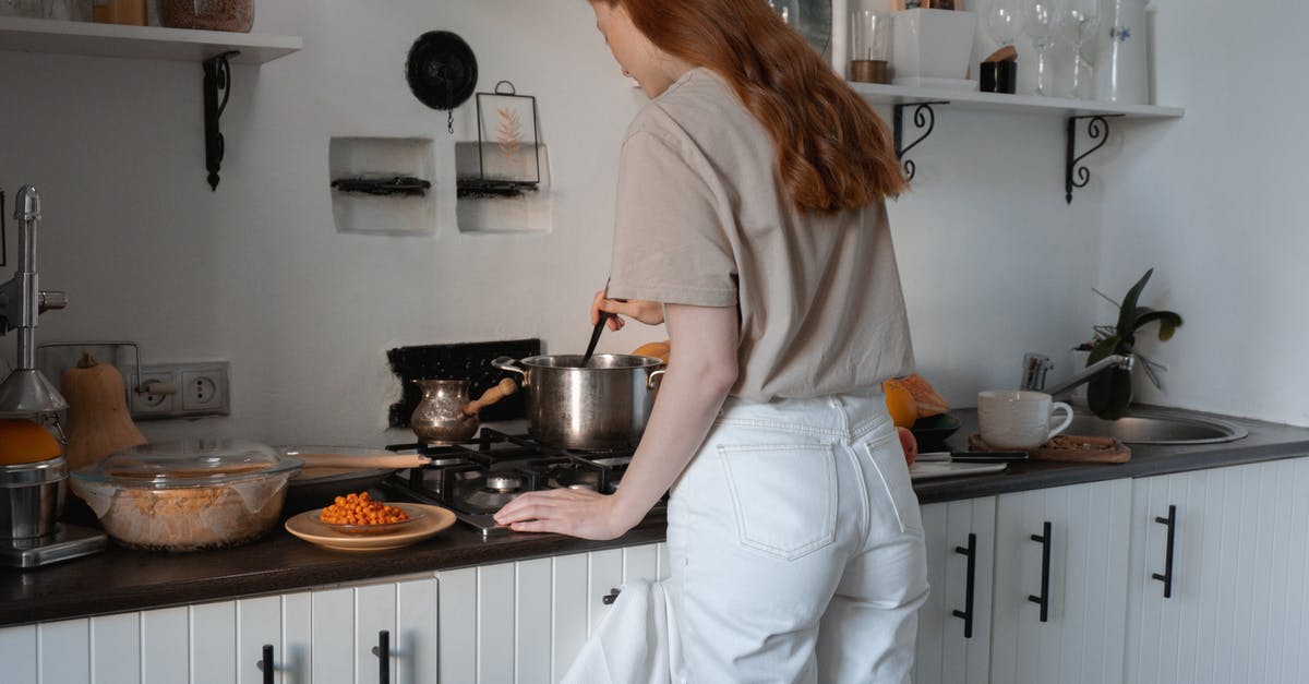 De-meatifying lasagna, casseroles - Woman in Brown Shirt and White Pants Standing in Front of Stove De-meatifying lasagna, casseroles - Woman in Brown Shirt and White Pants Standing in Front of Stove