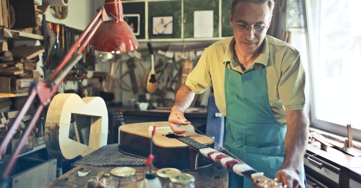 Determining a wok's material - Photo of Man Making an Acoustic Guitar Determining a wok's material - Photo of Man Making an Acoustic Guitar