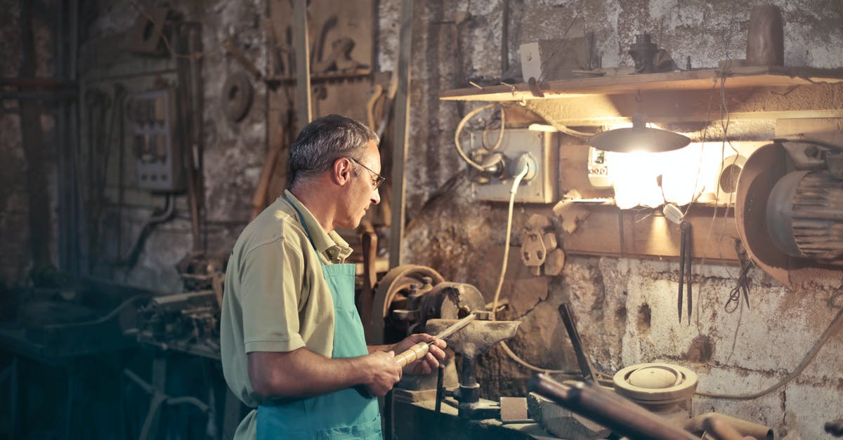 Determining a wok's material - Photo of Man Standing Inside His Workshop Determining a wok's material - Photo of Man Standing Inside His Workshop