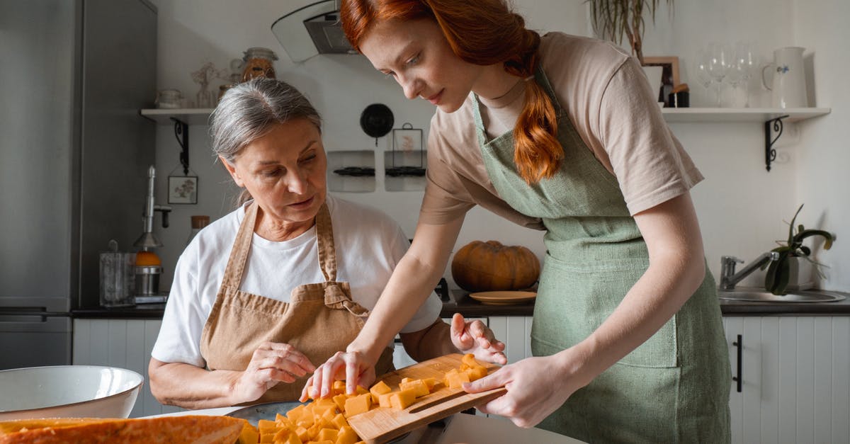 Dicing roasted pumpkin instead of puréeing it? - Woman Wearing an Apron Holding a Chopping Board Dicing roasted pumpkin instead of puréeing it? - Woman Wearing an Apron Holding a Chopping Board
