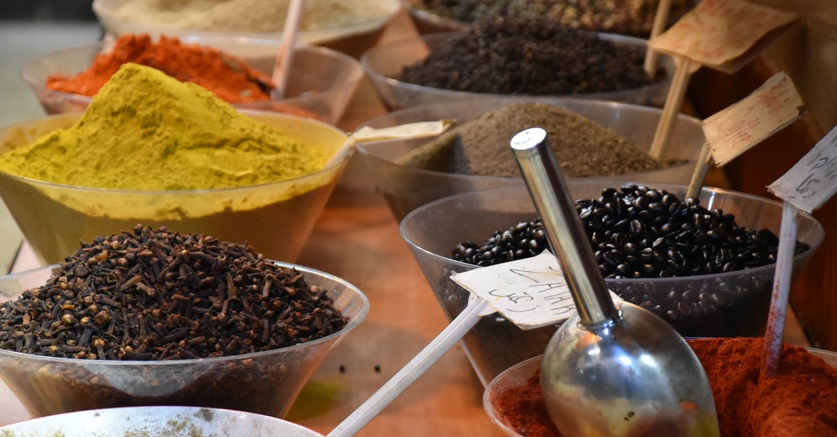 Difference between curry and tikka masala? - From above of bowls full of various dry seasonings on table in street bazaar Difference between curry and tikka masala? - From above of bowls full of various dry seasonings on table in street bazaar