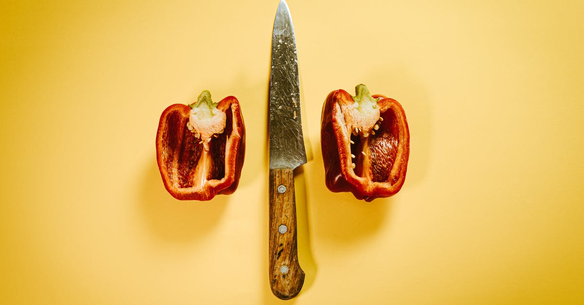 Difference between natural and organic - Cut red bell pepper with knife on surface Difference between natural and organic - Cut red bell pepper with knife on surface