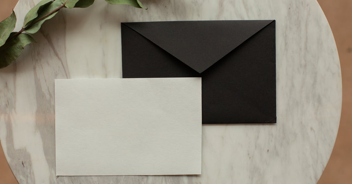 Difference between natural and organic - Top view of blank black envelope with white card placed on table with pencil and dry green sprig in modern room Difference between natural and organic - Top view of blank black envelope with white card placed on table with pencil and dry green sprig in modern room