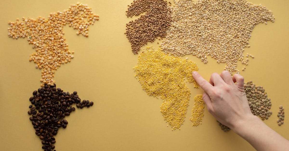 Difference in caffeine levels between light and bold coffee? - Top view of crop unrecognizable traveler making world continents with assorted grains and coffee beans on yellow background in room Difference in caffeine levels between light and bold coffee? - Top view of crop unrecognizable traveler making world continents with assorted grains and coffee beans on yellow background in room