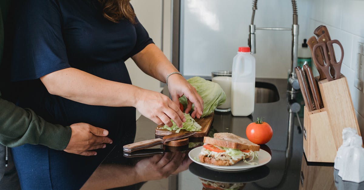 Do burgers cook better when close or far apart? - Crop anonymous couple hugging and cooking fresh healthy sandwiches while spending time together in kitchen at home Do burgers cook better when close or far apart? - Crop anonymous couple hugging and cooking fresh healthy sandwiches while spending time together in kitchen at home