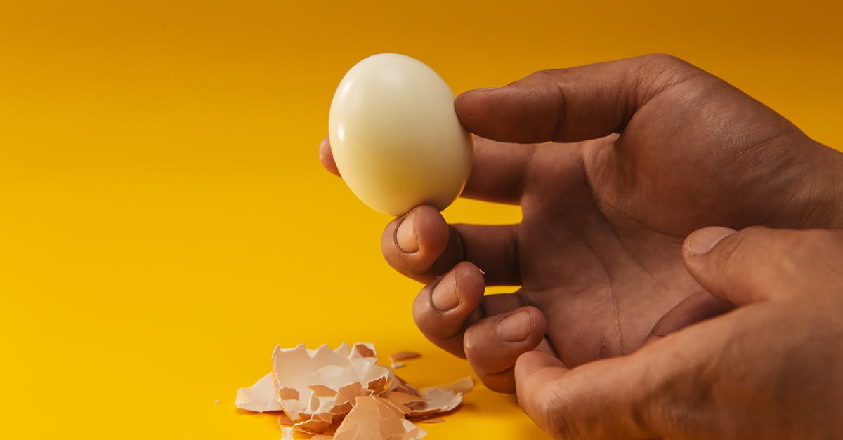 Do eggshells let flavours pass through during boiling? - Person Holding Boiled Egg Do eggshells let flavours pass through during boiling? - Person Holding Boiled Egg