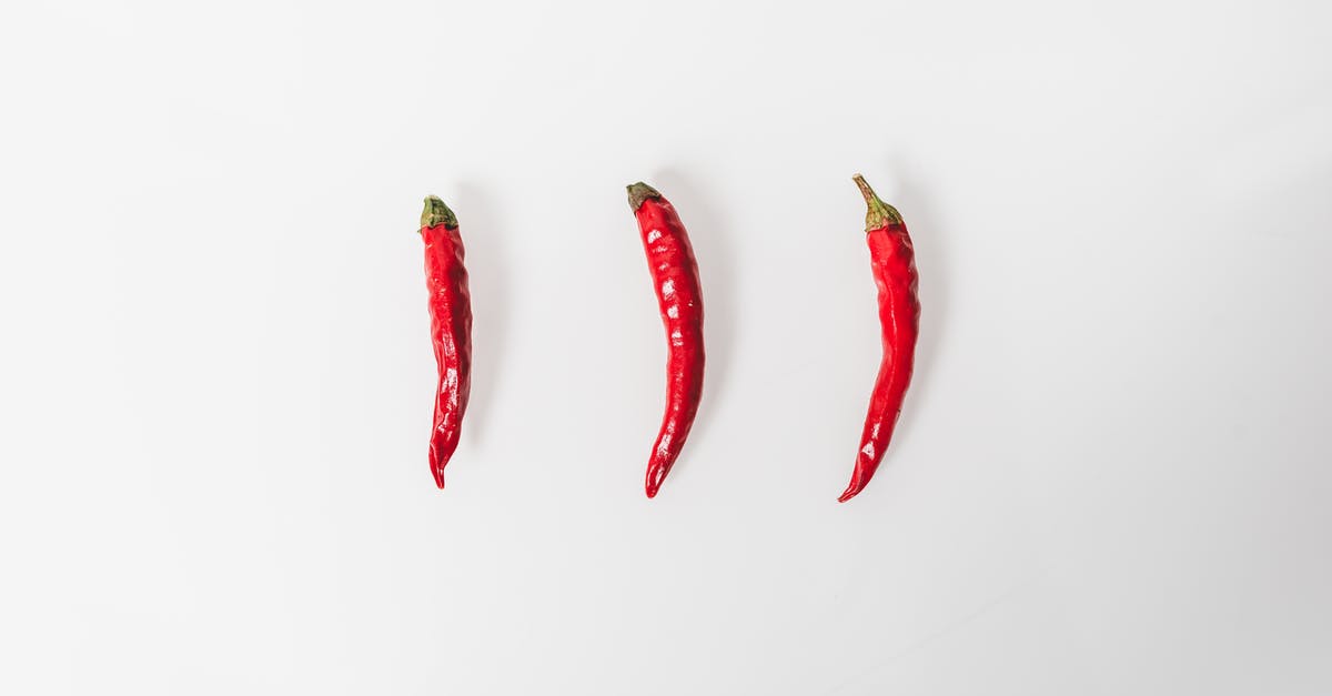 Do fresh chilli peppers have properties that ground chilli peppers do not? - Three Red Chili Peppers on a White Surface Do fresh chilli peppers have properties that ground chilli peppers do not? - Three Red Chili Peppers on a White Surface