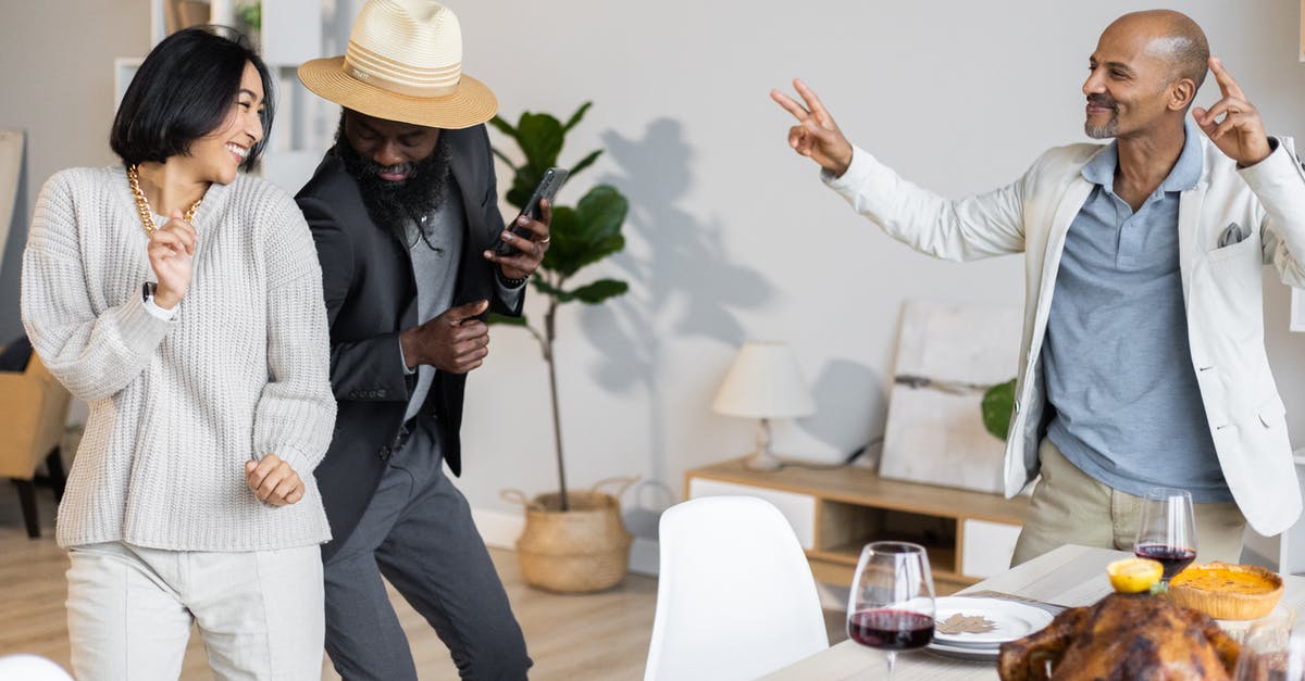 Do I have to tie my turkey legs together? - Happy multiethnic friends dancing together near table with dishes Do I have to tie my turkey legs together? - Happy multiethnic friends dancing together near table with dishes