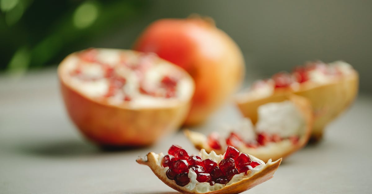 Do I need to peel a red kuri squash? - Chunk of ripe pomegranate with red seeds placed on surface near halves of tasty fruit on blurred background in kitchen Do I need to peel a red kuri squash? - Chunk of ripe pomegranate with red seeds placed on surface near halves of tasty fruit on blurred background in kitchen