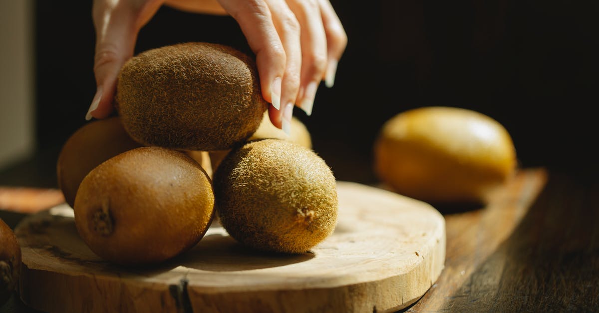 Do nutritional facts take into account the inedible parts of certain foods? - Woman taking whole unpeeled kiwi from wooden board Do nutritional facts take into account the inedible parts of certain foods? - Woman taking whole unpeeled kiwi from wooden board