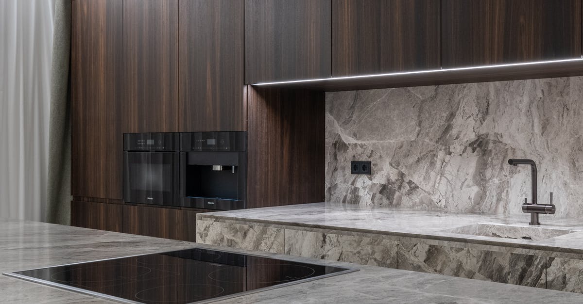 Does an induction stove require flat bottomed vessels? - Interior design of spacious stylish modern kitchen with induction stove and air extraction system with wooden cupboards Does an induction stove require flat bottomed vessels? - Interior design of spacious stylish modern kitchen with induction stove and air extraction system with wooden cupboards