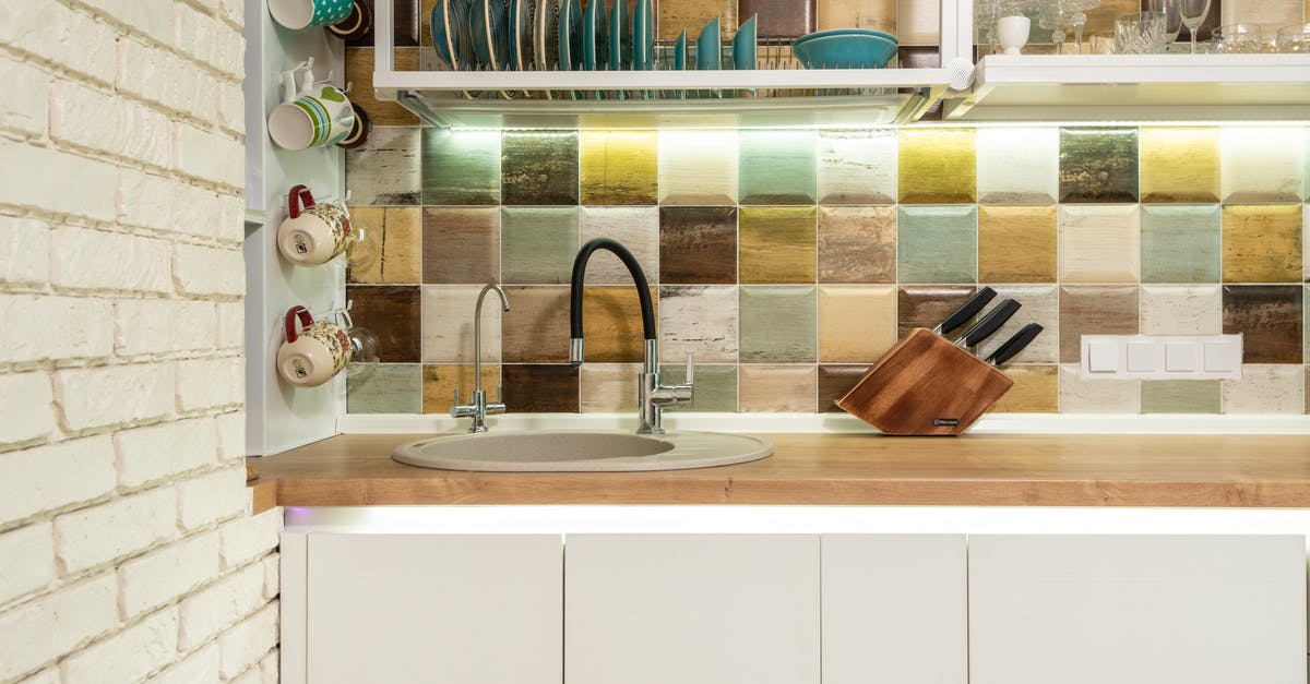 Does ceramic non-stick cookware "fail", and if so, how? - Interior of bright kitchen corner furnished with wooden counter and white cupboards decorated with various dishware and glasses against tiled wall