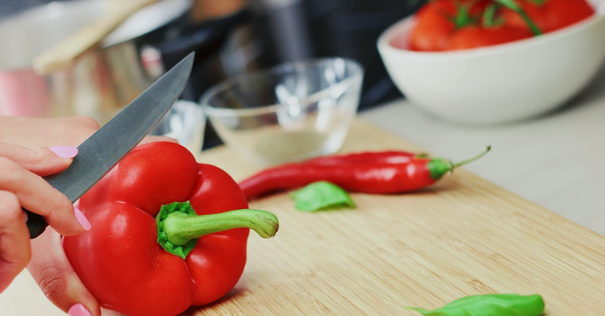 Does chilli get milder with cooking? - Person Slicing Red Chili Pepper on Brown Wooden Chopping Board Does chilli get milder with cooking? - Person Slicing Red Chili Pepper on Brown Wooden Chopping Board