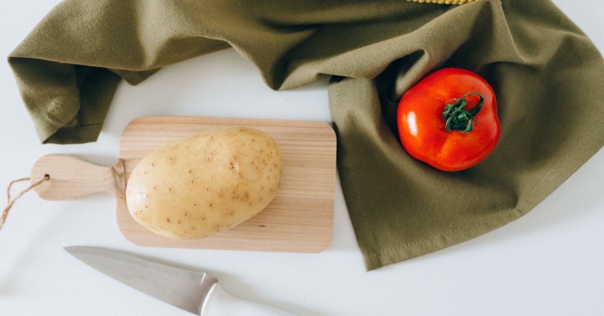 Does chopping vegetables remove vitamins? - A Potato on a Wooden Chopping Board Beside a Tomato and Corn Does chopping vegetables remove vitamins? - A Potato on a Wooden Chopping Board Beside a Tomato and Corn