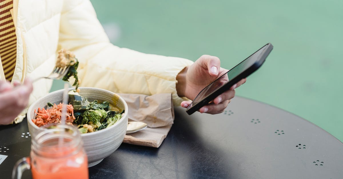 Does frozen broccoli need to be cooked to be eaten safely? - Crop woman with smartphone and vegetable salad in street cafeteria Does frozen broccoli need to be cooked to be eaten safely? - Crop woman with smartphone and vegetable salad in street cafeteria