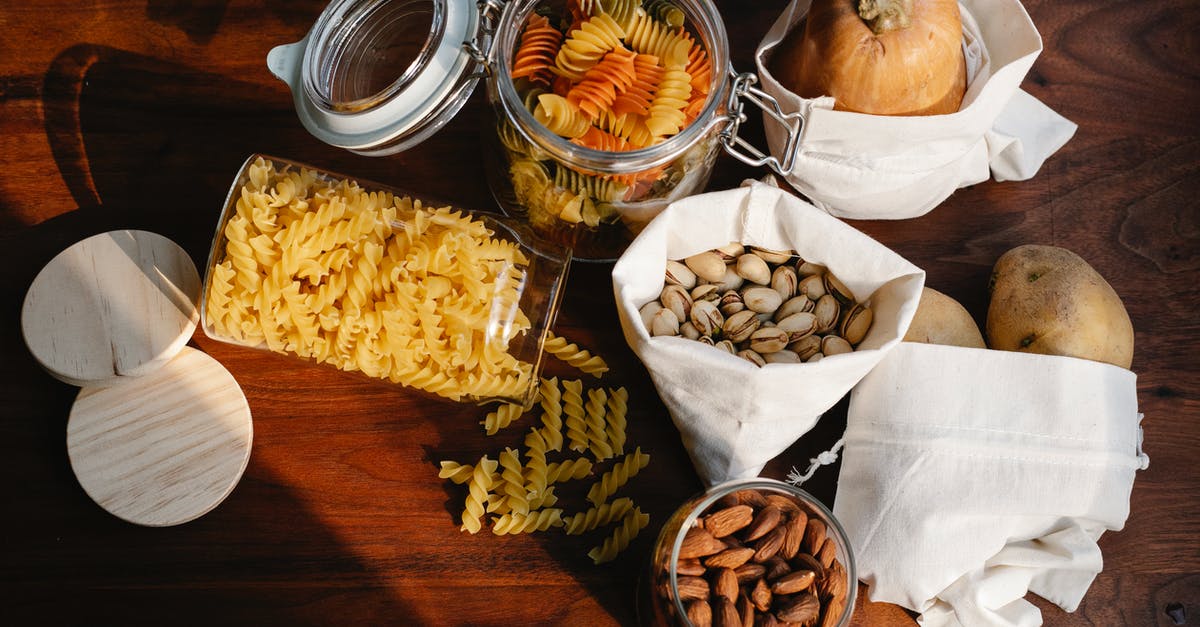Does pistachio ice cream need pistachio nut chunks in it? - Top view jars of raw pasta placed on wooden table near ECO friendly sacks with pistachios and almonds near pumpkin and potatoes