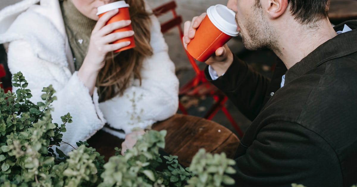 Does polenta 'go off'? - Crop man and woman drinking coffee to go in street cafeteria Does polenta 'go off'? - Crop man and woman drinking coffee to go in street cafeteria
