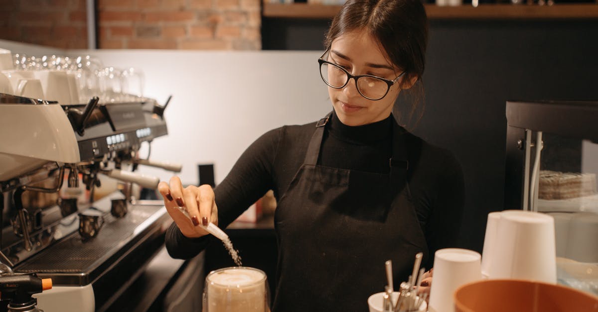Does putting salt in coffee really remove bitterness? - A Woman Pouring a Sachet of Sugar in a Glass of Coffee at the Counter Does putting salt in coffee really remove bitterness? - A Woman Pouring a Sachet of Sugar in a Glass of Coffee at the Counter