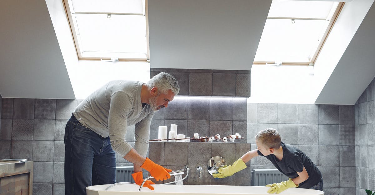 Does soaking in saltwater for 20 mins help cleanse mussels? - Side view of grey haired dad with beard in orange rubber gloves cleaning bathroom together with son Does soaking in saltwater for 20 mins help cleanse mussels? - Side view of grey haired dad with beard in orange rubber gloves cleaning bathroom together with son