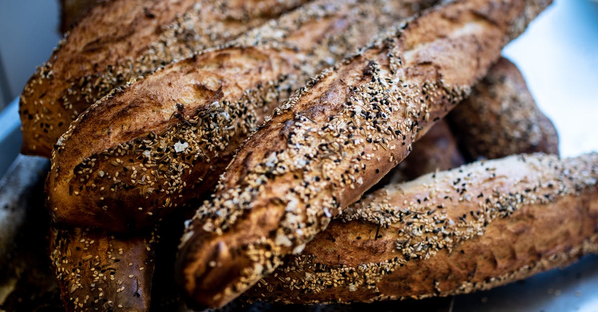 Does the addition of acid into flour inhibit gluten formation? - Closeup of delicious crunchy baguettes placed on metal counter in kitchen of bake house