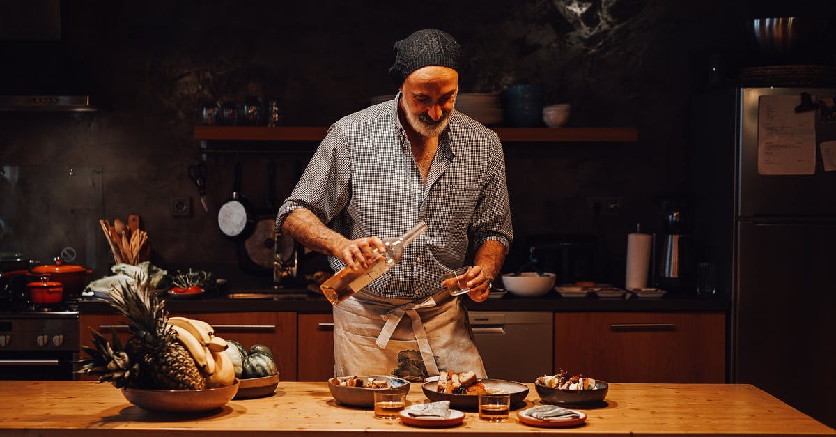 Does the alcohol in wine affect cooking process? - Aged male in apron pouring wine into shot glass while standing at table and assembling order in kitchen Does the alcohol in wine affect cooking process? - Aged male in apron pouring wine into shot glass while standing at table and assembling order in kitchen