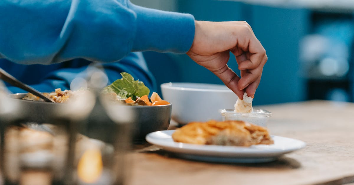 Does the dish lose flavor when it releases a lot of smell? [duplicate] - Crop unrecognizable male tasting delicious food with delicate sauce at timber table on blurred background