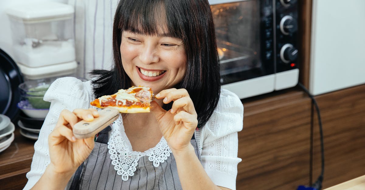 Does there exist a chemical-free, homemade substitute to deli? - Happy Asian woman enjoying eating slice of cheesy pizza sitting at table in kitchen Does there exist a chemical-free, homemade substitute to deli? - Happy Asian woman enjoying eating slice of cheesy pizza sitting at table in kitchen