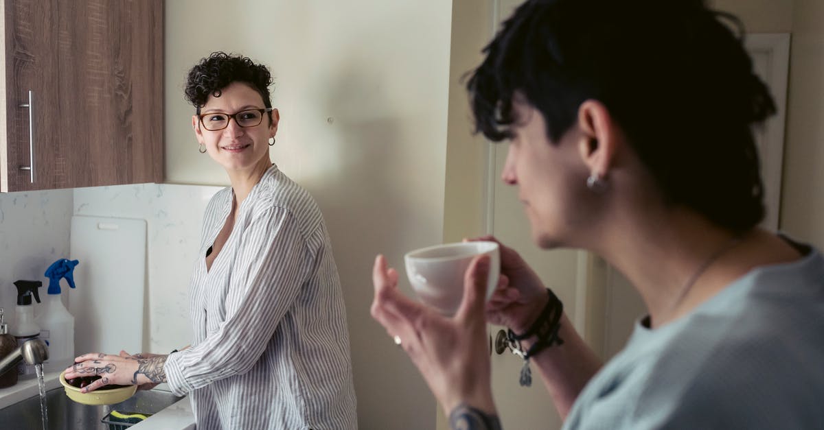 Does washing kimchi with water reduce the sodium content much? - Positive young woman washing fruits and talking with girlfriend drinking coffee Does washing kimchi with water reduce the sodium content much? - Positive young woman washing fruits and talking with girlfriend drinking coffee