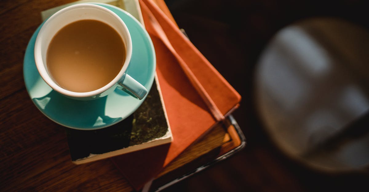 Domestic, fresh taste-alike for an Italian coffee - From above of ceramic cup of hot aromatic coffee placed on book and notepad Domestic, fresh taste-alike for an Italian coffee - From above of ceramic cup of hot aromatic coffee placed on book and notepad