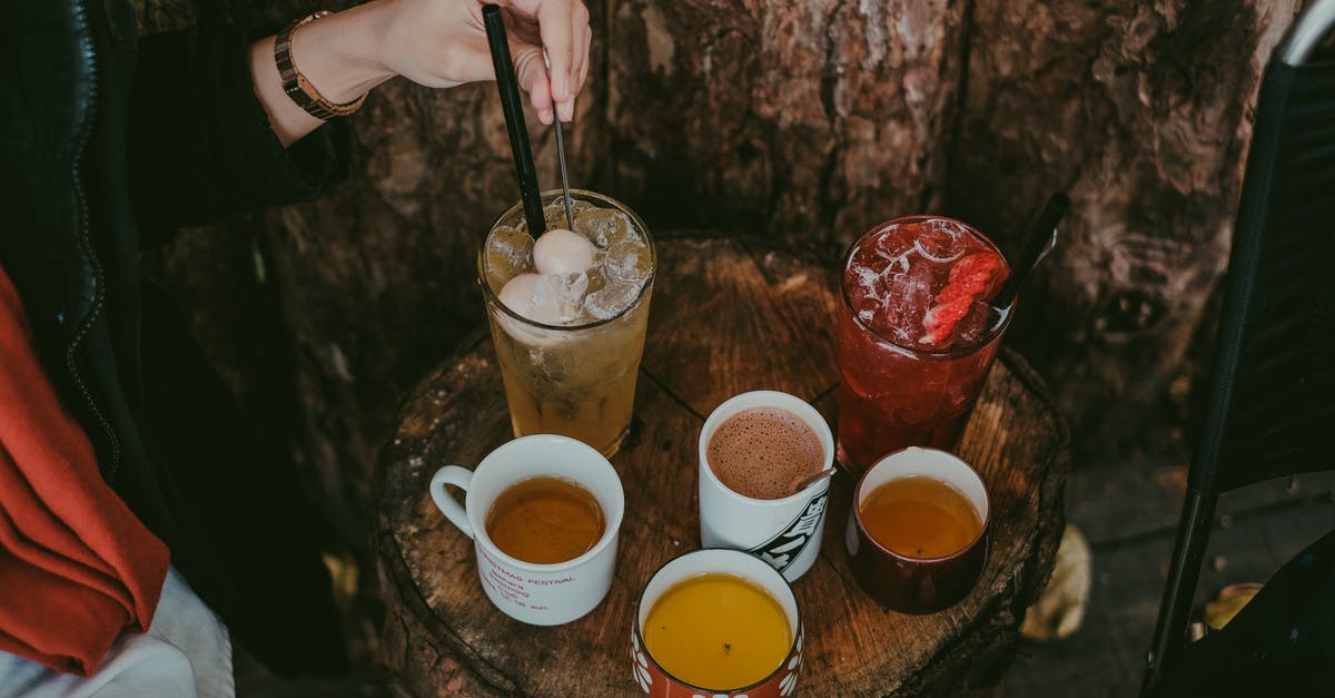 Donvier Ice Cream Maker - why stirring only every 2 minutes? - A Person Stirring a Cold Beverage on a Wooden Table with Assorted Drinks Donvier Ice Cream Maker - why stirring only every 2 minutes? - A Person Stirring a Cold Beverage on a Wooden Table with Assorted Drinks