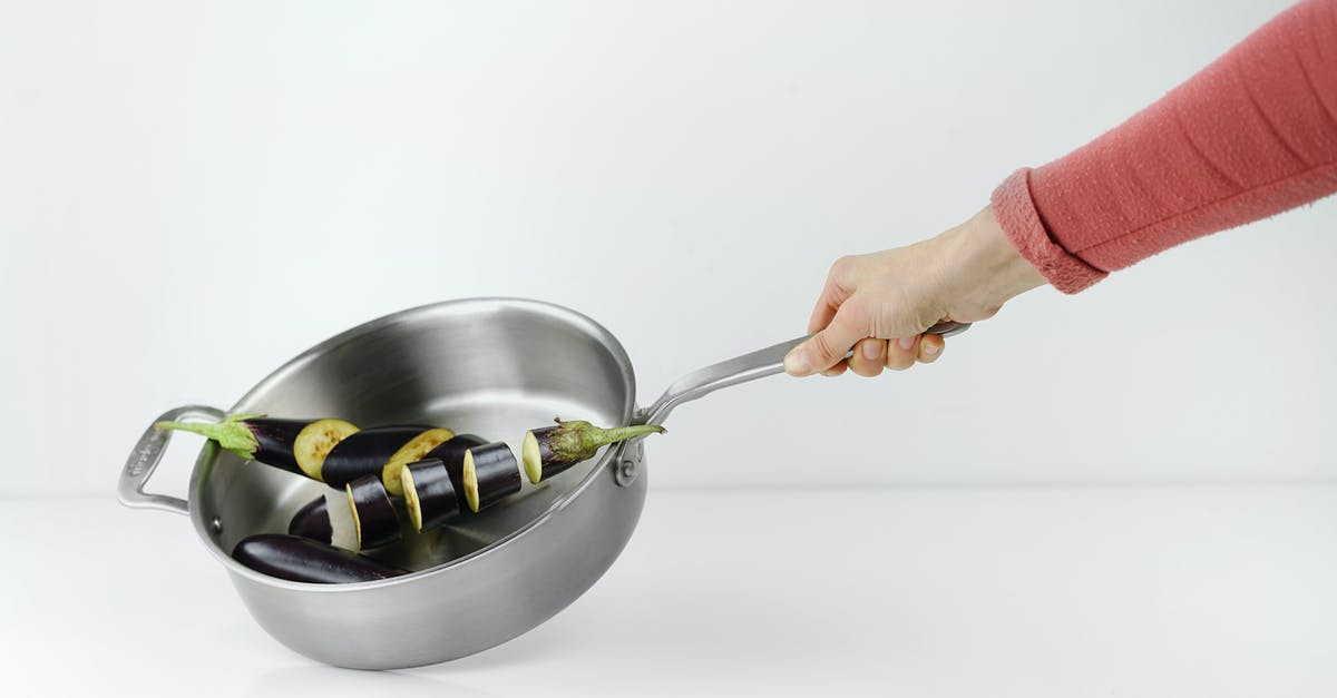 Dosa on clad stainless steel pan - Person Holding Stainless Steel Casserole