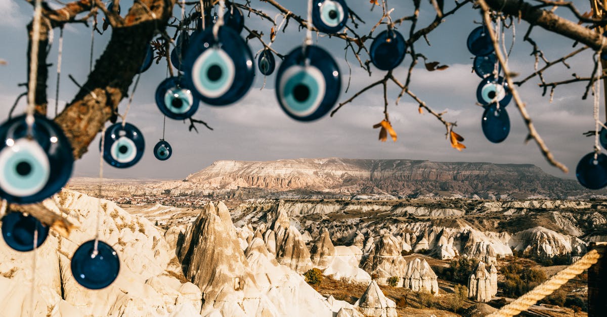 Dry Brining Turkey - Nazar amulets on threads hanging from tree branches near rocky uneven formations with mountains and grass with plants in Turkey in Cappadocia region under gray cloudy sky in summer day Dry Brining Turkey - Nazar amulets on threads hanging from tree branches near rocky uneven formations with mountains and grass with plants in Turkey in Cappadocia region under gray cloudy sky in summer day