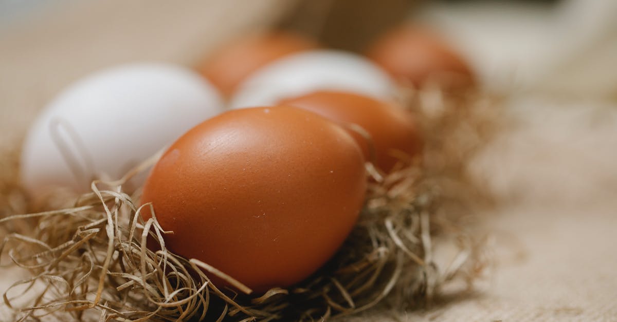 Dry cured chicken with bad odor - Fresh chicken eggs placed in straw on table with cloth in soft focus