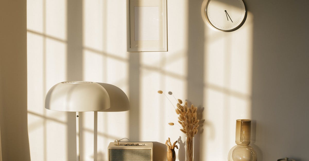 Dry-aging at home - Light room with retro radio and decorative vases with dry plants on desk near wall with clock and window shadow in sunlight Dry-aging at home - Light room with retro radio and decorative vases with dry plants on desk near wall with clock and window shadow in sunlight