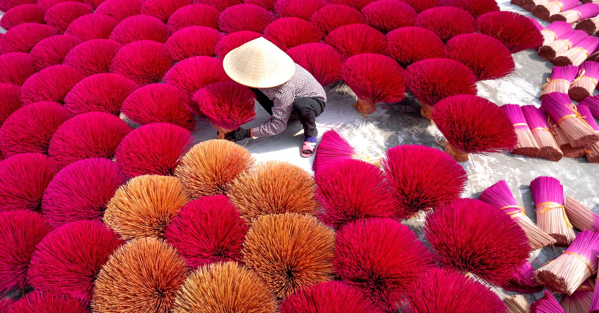 Drying fresh produce after washing - From above of man in white Asian conical hat preparing colorful sticks for producing aromatic sticks in Vietnam incense village Drying fresh produce after washing - From above of man in white Asian conical hat preparing colorful sticks for producing aromatic sticks in Vietnam incense village