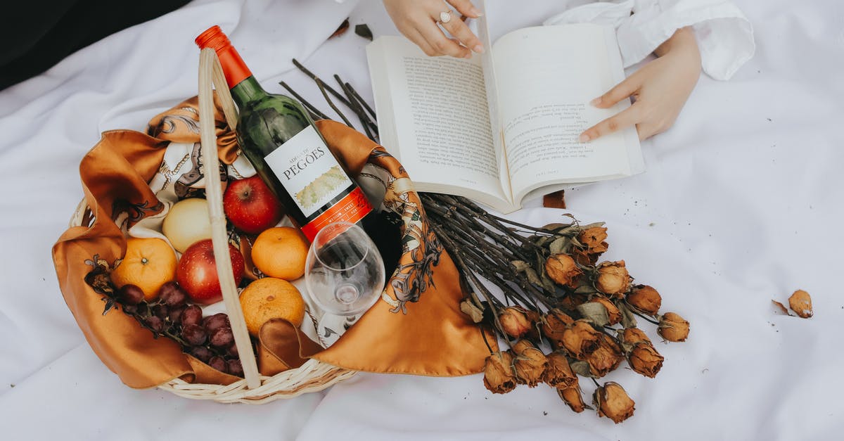 Drying fruits with a household dehydrator - A Person Holding a Book Near the Basket with Fruits and Wine Bottle Drying fruits with a household dehydrator - A Person Holding a Book Near the Basket with Fruits and Wine Bottle