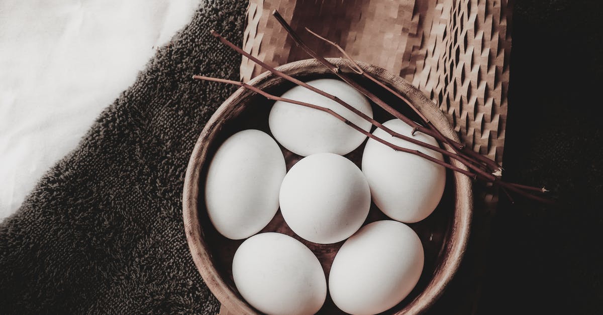 Drying whole, small fish at home - From above of eggs in wicker bowl with branches placed on paper above towel