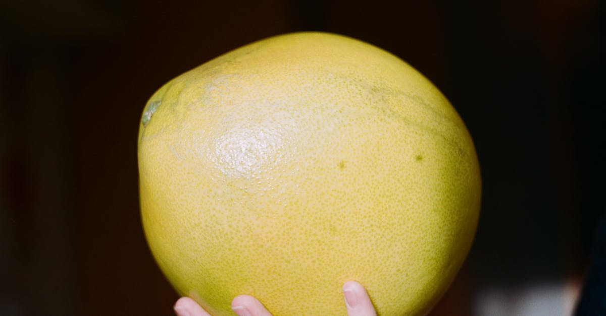 Easiest way to peel pomelos? - Crop person showing bright fresh pomelo fruit Easiest way to peel pomelos? - Crop person showing bright fresh pomelo fruit