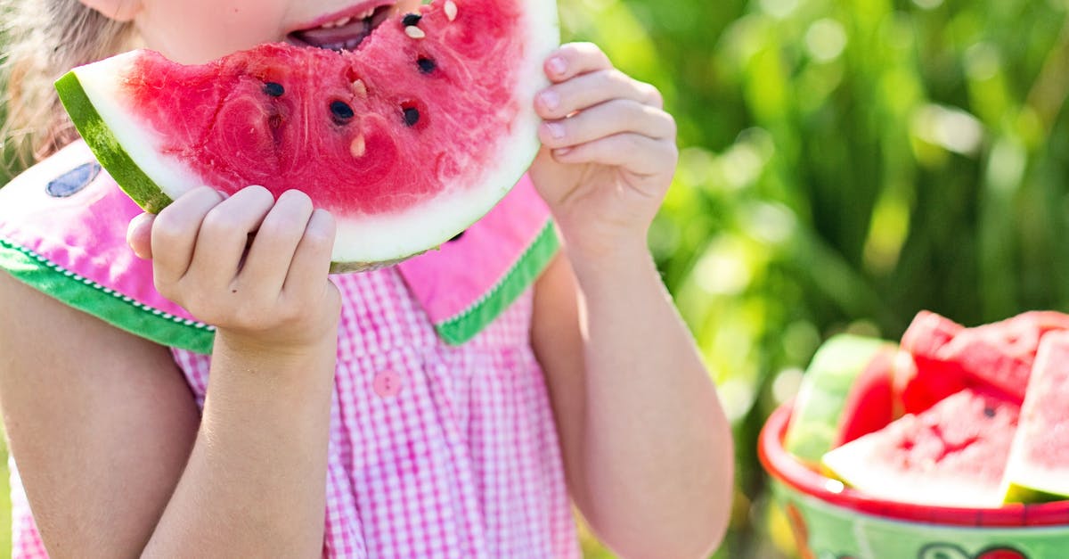 Eating dehydrated uncooked red potato - Girl Eating Sliced Watermelon Fruit Beside Table Eating dehydrated uncooked red potato - Girl Eating Sliced Watermelon Fruit Beside Table