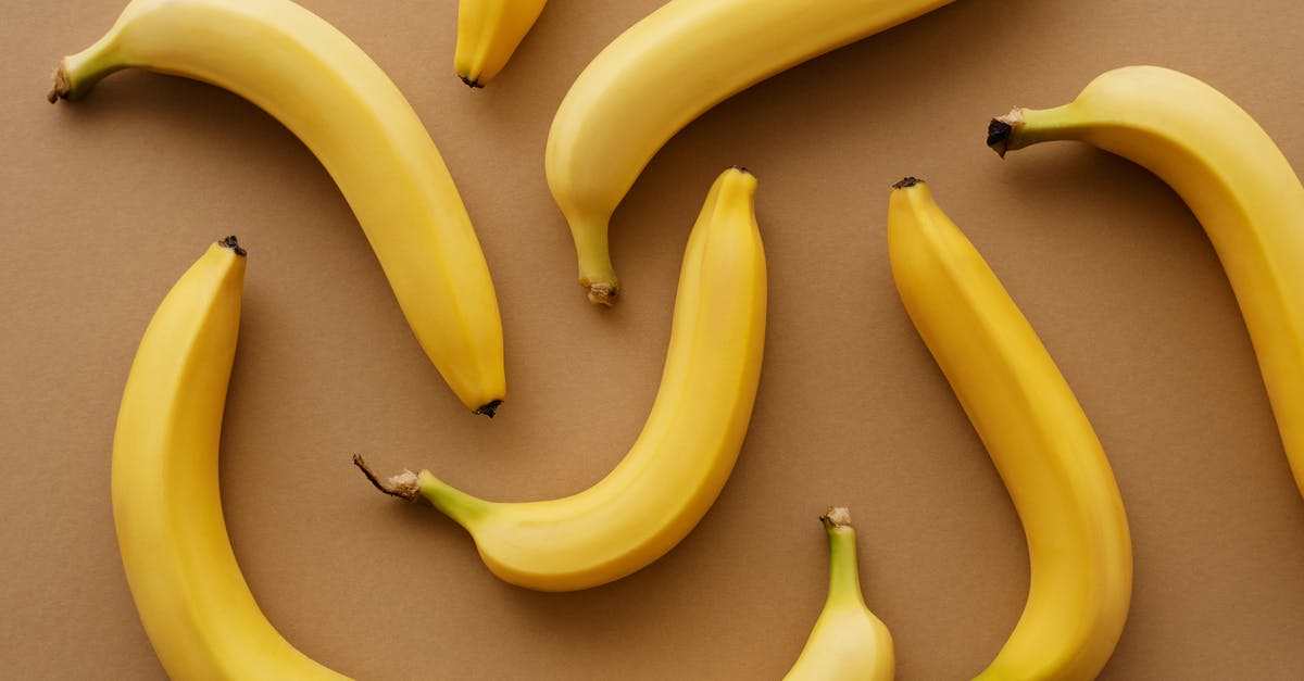 Eating mangoes with skin intact - Yellow Banana Fruits on Brown Surface Eating mangoes with skin intact - Yellow Banana Fruits on Brown Surface