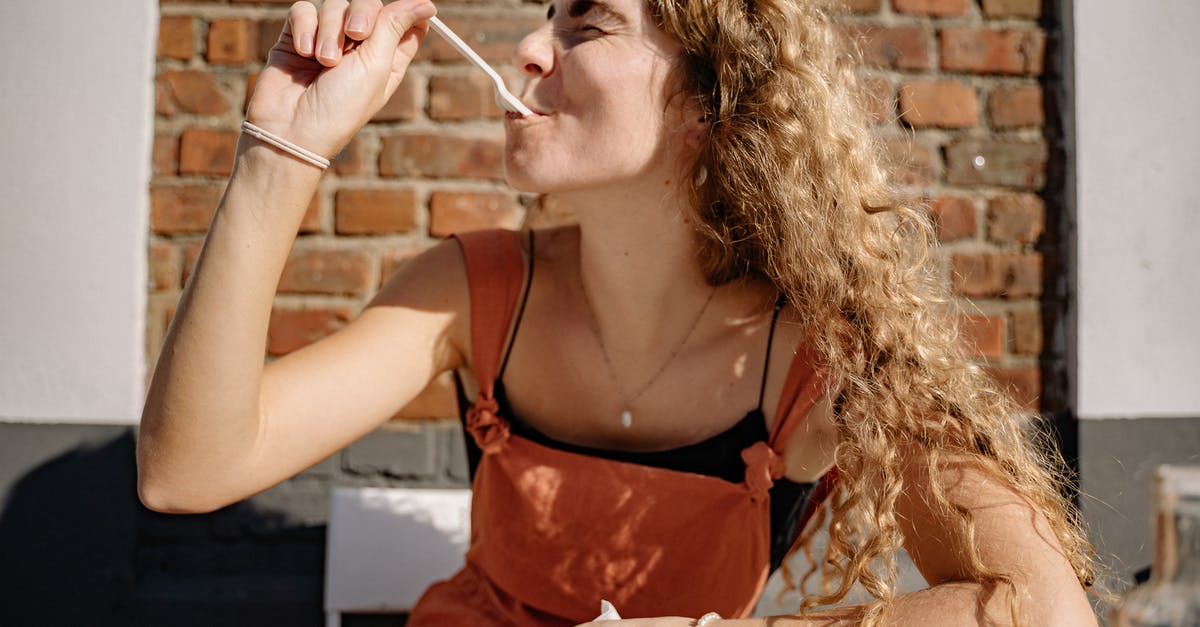 Eating with silvered cutlery - Woman Eating and Enjoying Her Food Eating with silvered cutlery - Woman Eating and Enjoying Her Food