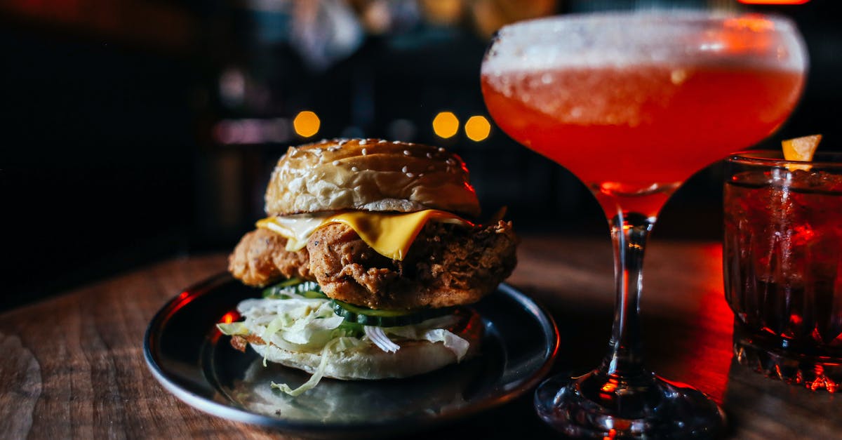 Effect of ethanol concentration on bread flavor - Appetizing hamburger with fried meat and lettuce served on wooden table with red alcoholic drink in modern cafe on blurred background Effect of ethanol concentration on bread flavor - Appetizing hamburger with fried meat and lettuce served on wooden table with red alcoholic drink in modern cafe on blurred background