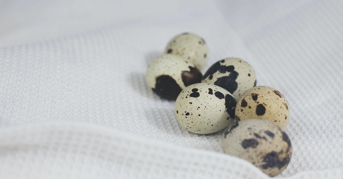 Egg shells speckled after cooking - Quail Eggs on White Fabric Egg shells speckled after cooking - Quail Eggs on White Fabric