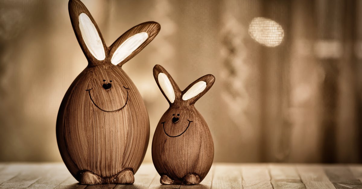 Egg sizes of yesteryear and today - Wooden eggs in form of rabbits with big ears and lines with dots representing muzzle placed on table in room with artificial light during Easter holiday Egg sizes of yesteryear and today - Wooden eggs in form of rabbits with big ears and lines with dots representing muzzle placed on table in room with artificial light during Easter holiday